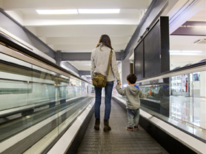 Mãe e filho no aeroporto com passaportes antes de viagem internacional