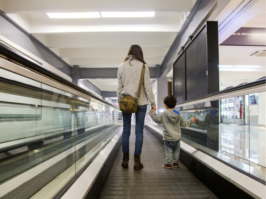 Mãe e filho no aeroporto com passaportes antes de viagem internacional